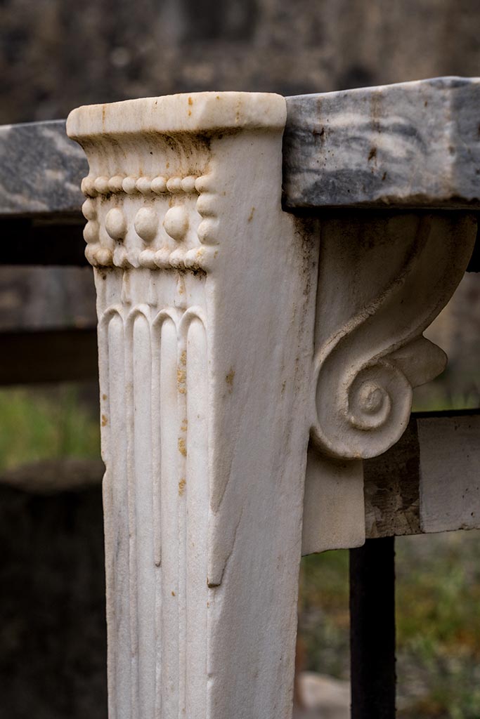 IX.14.4 Pompeii. July 2024. 
Detail of front table leg on west side of table. Photo courtesy of Johannes Eber.
