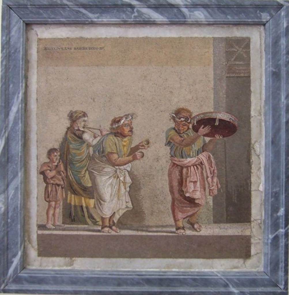 HGW06 Pompeii.  Found on 8th April 1763.  Ambiente 13 of Villa of Cicero.  Mosaic of a Group of Street Musicians. It bears the signature of Dioskourides of Samos.  Now in Naples Archaeological Museum. Inventory number 9985.