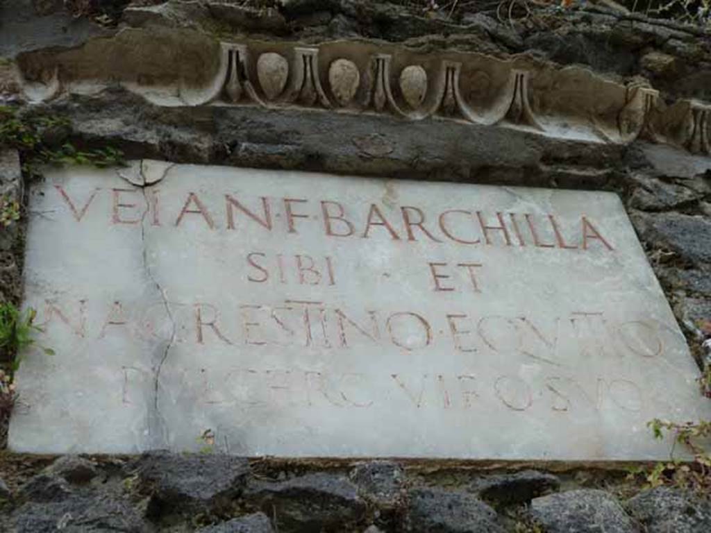 Pompeii Porta Nocera. May 2010. Tomb 3ES, white marble plaque, with decorative stucco above. 
The Latin inscription reads:
VEIA N(umeri) F(ilia) BARCHILLA
SIBI ET
N(umerio) AGRESTINO EQVITIO
PVLCHRO VIRO SVO.
