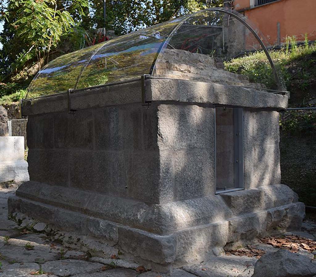SG5 Pompeii. 2018. Tomb on side facing south away from the Stabian Gate.
The tomb is an almost square shaped structure formed of an elevated foundation of grey tuff parallelepiped blocks, joined together by metallic clamps (at least on the northern side), onto which the roofing was built, consisting of a series of small steps of earth, lava stones, limestone chips and mortar, of which at least the lowest was conserved in situ. 
Within the burial chamber, there are niches in three sides of the brick wall. 
At the time of the 2001 excavation, two glass cinerary urns with lids were found; the tomb also contained two blown glass doves and a small jug.
See http://pompeiisites.org/en/comunicati/the-tombs-of-the-necropolis-of-porta-stabia/