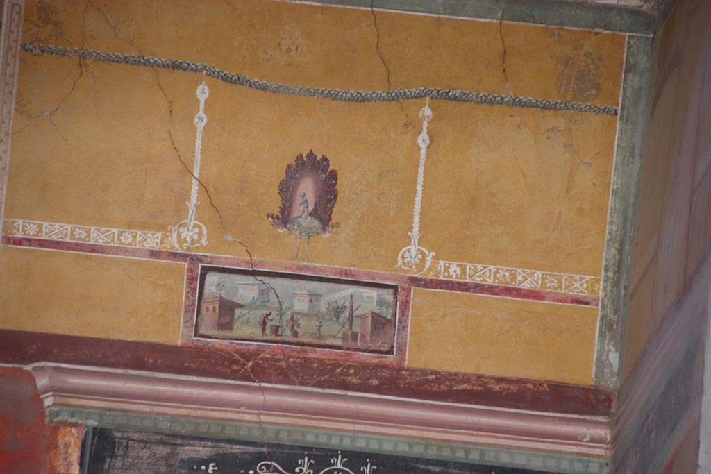 Oplontis Villa of Poppea, October 2022. Room 8, painted upper east wall at south end of recess. 
Beneath the painted peacock is a panel which maybe shows a man making a sacrifice on an altar, watched by a woman and a boy.  
Photo courtesy of Klaus Heese.
