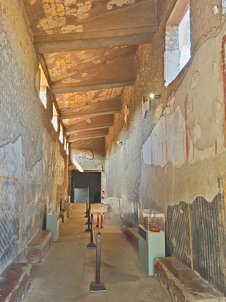 Oplontis Villa of Poppea, October 2023. 
Corridor 46, with benches and modern display cases, looking west. Photo courtesy of Giuseppe Ciaramella.
