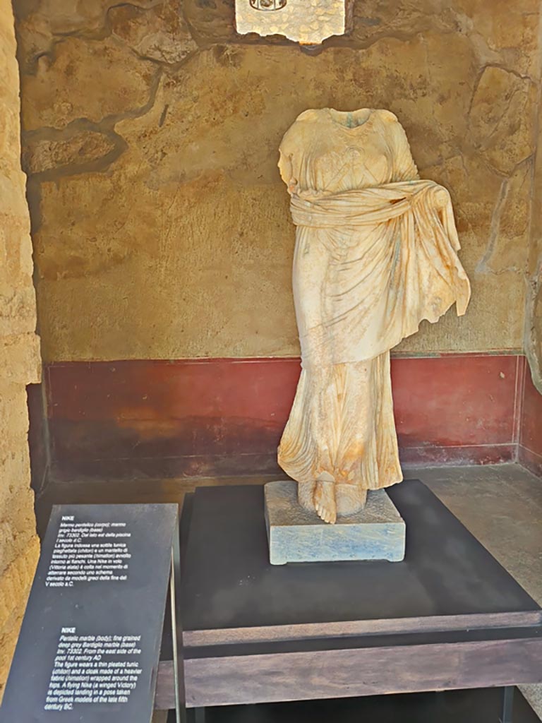 Oplontis Villa of Poppea, October 2023. 
Room 72, looking west through doorway with marble statue of Nike (inv. 73302) on display, which was found in 1983 on the east side of the pool.
Photo courtesy of Giuseppe Ciaramella. 

