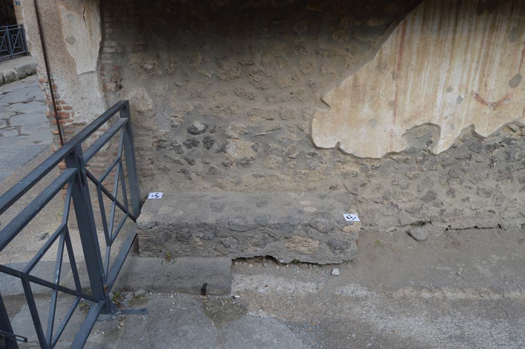 Pompeii Street Altar at I.8.1. October 2018. Bench at junction of Via dell’Abbondanza and Vicolo dell’Efebo, below street shrine.
Foto Taylor Lauritsen, ERC Grant 681269 DÉCOR.

