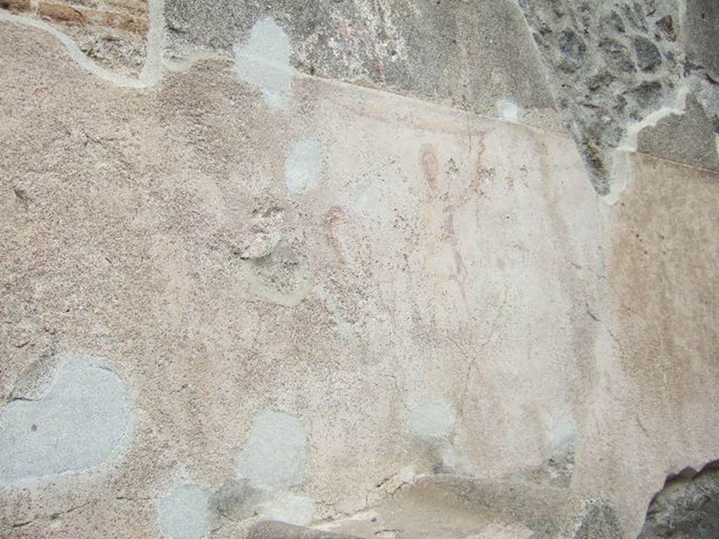 Pompeii street altar on west side wall of I.11.1. May 2006. 
Remains of painting above altar. The right hand Lar can be seen with his left hand raised holding a cornucopia. A curving line flows from the cornucopia, above his head and down to the situla (bucket) in his right hand. The curve of the serpent can be seen above the top of the painted round altar. 
The head is down to the left reaching into the burning offering on the top of the altar.  The garland can be seen above the Lar.
