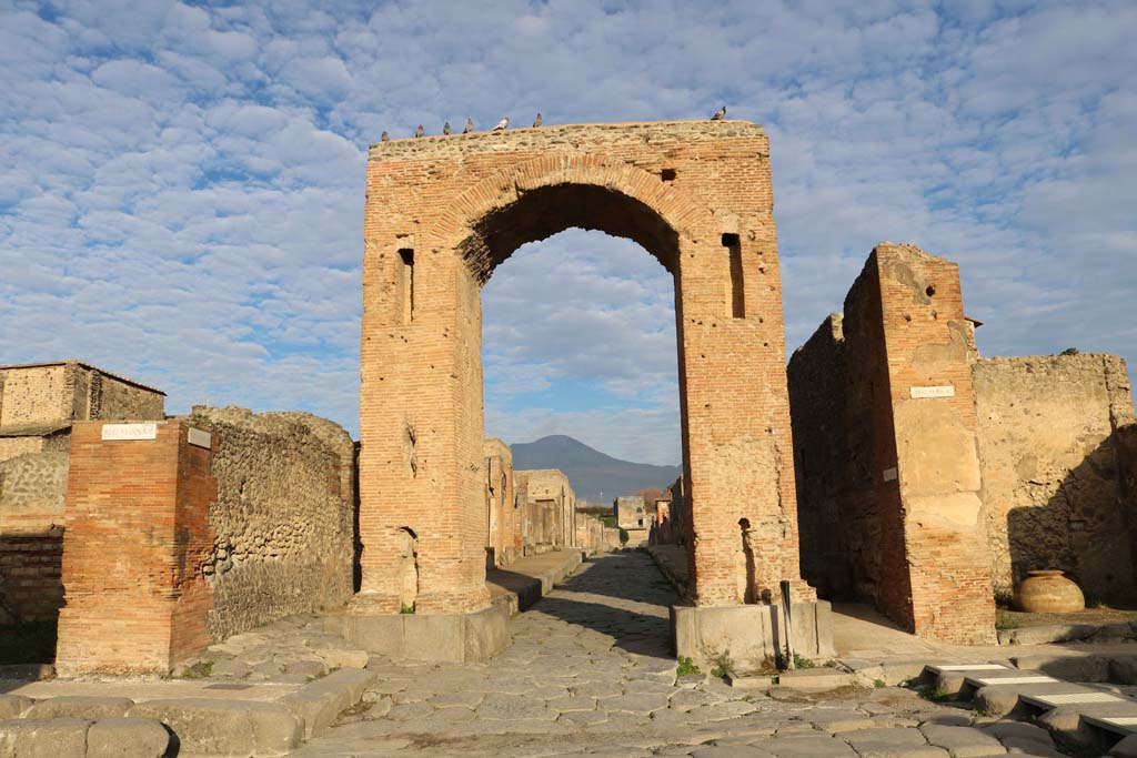 Arch of Caligula, Pompeii. December 2018.  
Looking north through the Arch of Caligula into Via di Mercurio, from crossroads of Via delle Terme, on left, and Via della Fortuna, on right. 
Photo courtesy of Aude Durand.
