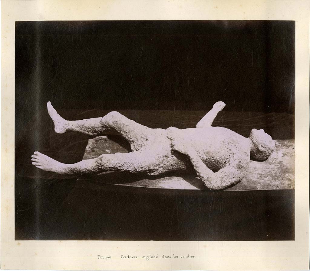 Plaster-cast of victim number 6. 
In his description of this plaster-cast in his Guida di Pompei, 1877, Fiorelli described –
“Man, no.6 lying on his back, with legs spread apart, his right arm extended, and his left hand near his belt, with sandals on his feet and a ring on his finger.
From his face he would appear to be an African. (Reg. IX, insula III, via secunda).
See Fiorelli, Guida di Pompei, [Rome, 1877,] p.88-89. 
See Dwyer, E., 2010. Pompeii’s Living Statues. Ann Arbor: University of Michigan Press, (p.93).
