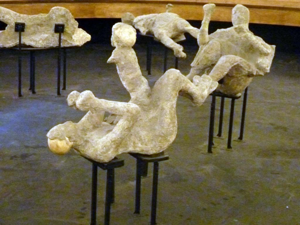 VI.17.42 Pompeii. Victims 51, 52 and 50 on display in the pyramid in the amphitheatre, September 2015. Plaster-casts of the family group.