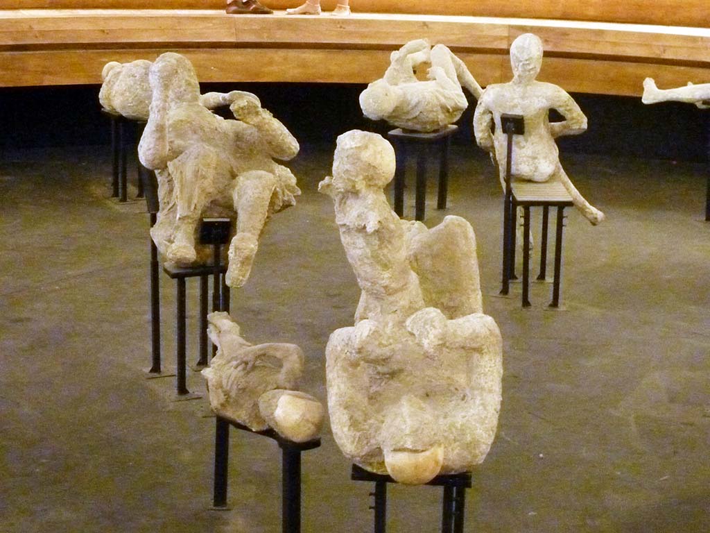 VI.17.42 Pompeii. Victims 50 to 53 on display in the pyramid in the amphitheatre, September 2015. Plaster-casts of the family group of four.
