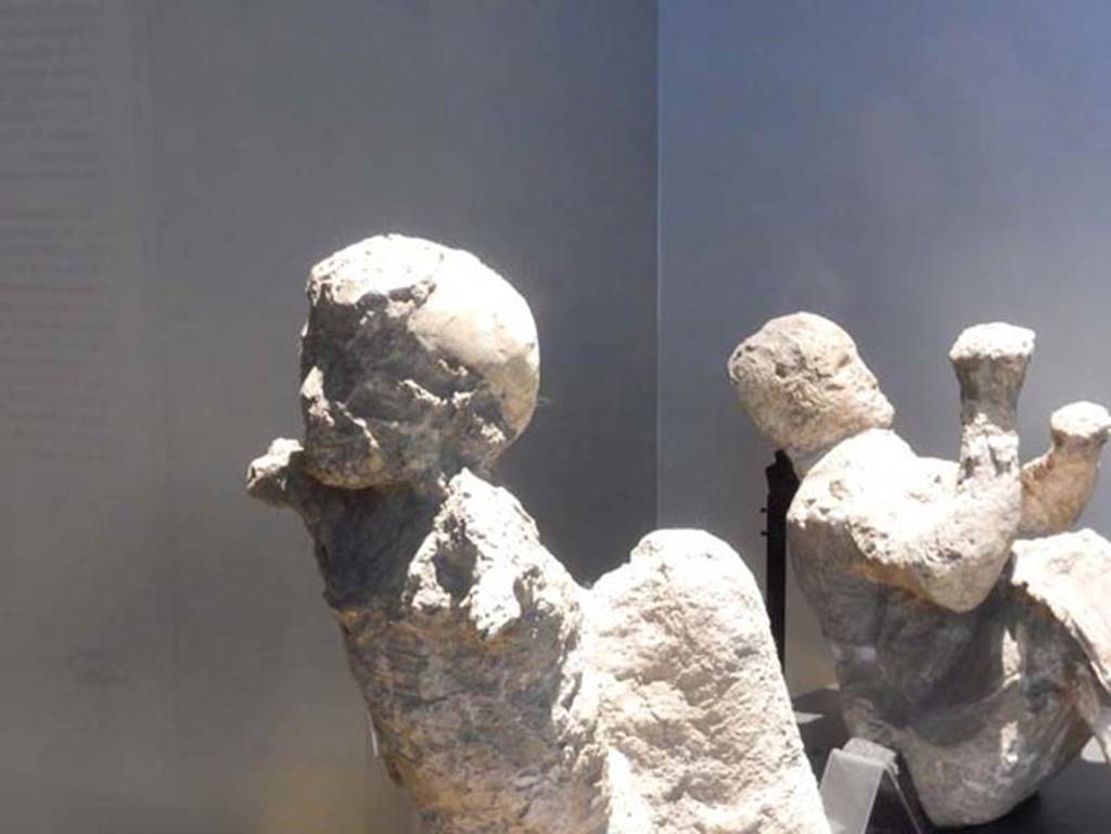 VI.17.42, Pompeii, May 2018. Plaster cast of a child (victim 51), on left, and man (victim 50), on right, found in the corridor leading to the garden area.
Photo courtesy of Buzz Ferebee.
