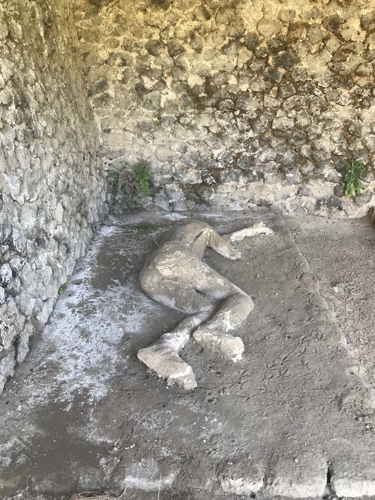 Pompeii, outside Porta Nocera. April 2019. Plaster cast of remains of a second fleeing victim found in 1956/7. 
Photo courtesy of Rick Bauer. 
