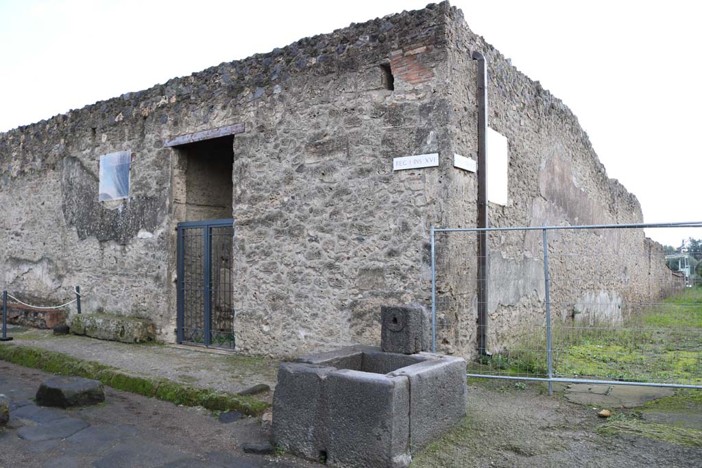 Fountain outside I.16.4. December 2018. Via di Castricio, south side (on left) with entrance doorway to I.16.4.
Junction with unnamed vicolo between I.16 and I.17, on right. Photo courtesy of Aude Durand.

