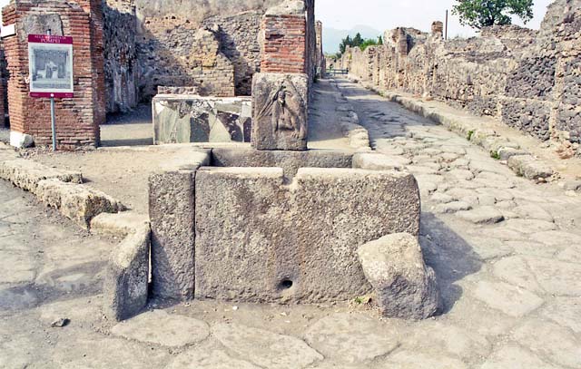 Fountain outside VI.3.20, Pompeii. October 2001. Looking north at junction of Via Consolare, on left,  and Vicolo di Modesto, on right. Photo courtesy of Peter Woods.
