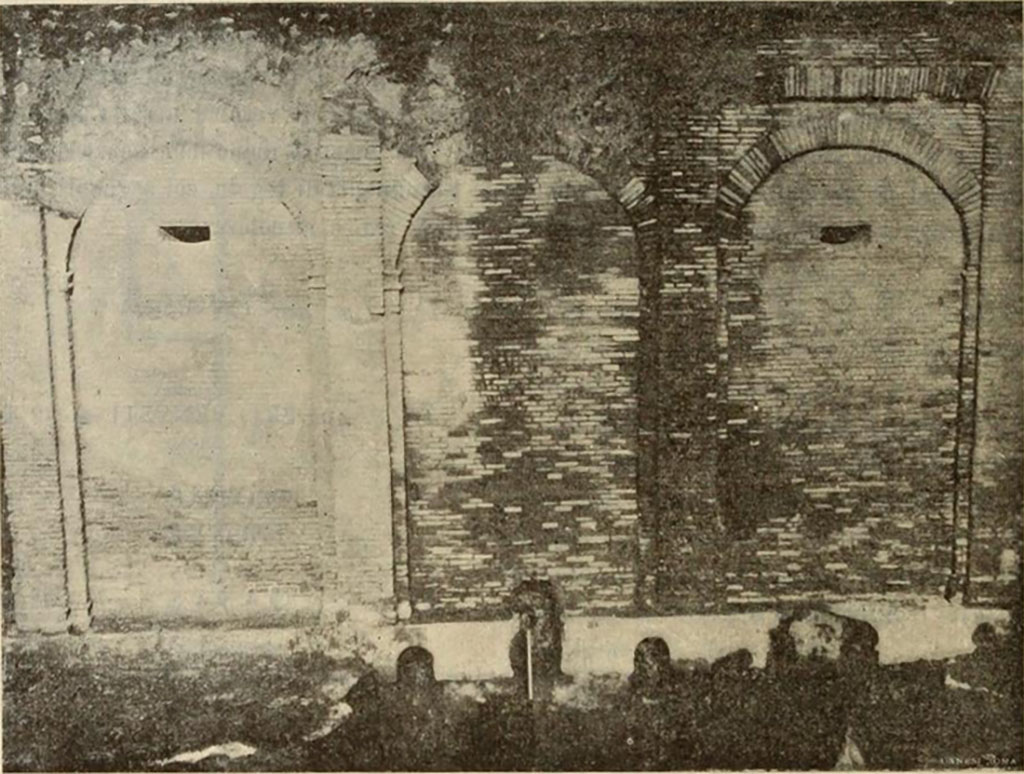 Castellum Aquae Pompeii. 1903 view of south side. 
The south side is the most ornate with four pillars bounding three arches.
On each of the pillars is the outline of a capital carved protruding from the bricks.
The three water exit channels are in the centre at the bottom.
The two windows are narrow slits on the outside but widen out more on the inside.
See Notizie degli Scavi di Antichità, 1903, p. 26, fig. 1.
