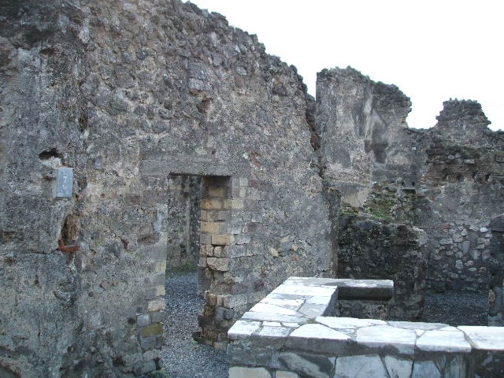 VI.4.3 Pompeii. December 2004. Looking west from entrance, across counter and towards linking doorway to VI.4.4. According to Boyce, in the west wall of the room with the counter were the ruins of a niche. Its walls were coated with white stucco and decorated with coloured spots. Its floor was a projecting tile.
See Boyce G. K., 1937. Corpus of the Lararia of Pompeii. Rome: MAAR 14. (p.45, no.150).
According to Garcia y Garcia due to the bombing, the niche to the west of the thermopolium has sadly disappeared. Also lost was the recess, perhaps for a bed in the south-east of the small rear room.
See Garcia y Garcia, L., 2006. Danni di guerra a Pompei. Rome: L’Erma di Bretschneider. (p.75)

