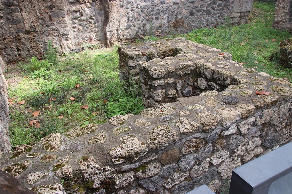 I.1.1 Pompeii. October 2024. Looking south-east across podium or sales counter, with hearth. Photo courtesy of Klaus Heese.