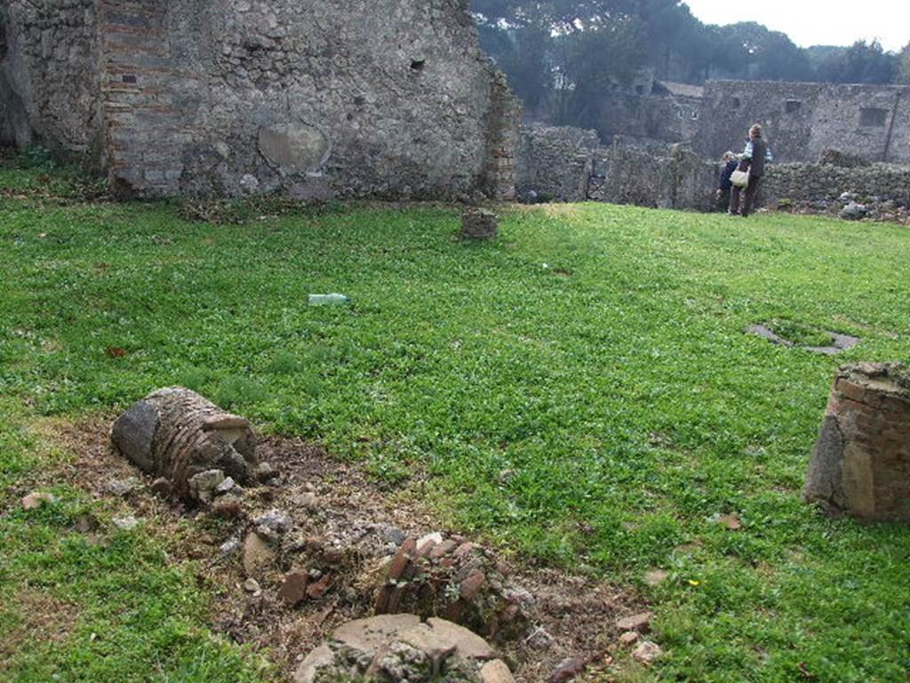 I.2.6 Pompeii. December 2006. Looking south west across peristyle, towards site of small room, cubiculum and room with stairs. (The area behind the figures is the house at I.2.3)
