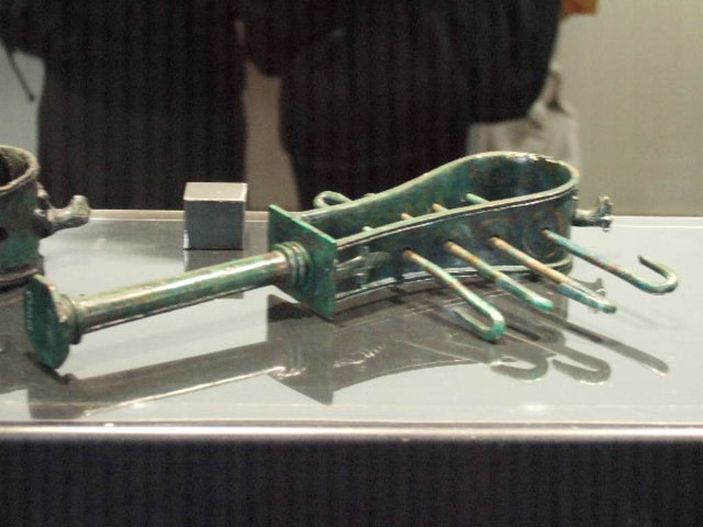 I.2.6 Pompeii.  Bronze sistrum found in I.2.6.  Now in Naples Archaeological Museum.  According to Fiorelli two bronze Sistri were found in the south east corner of the atrium, hanging by iron nails.
