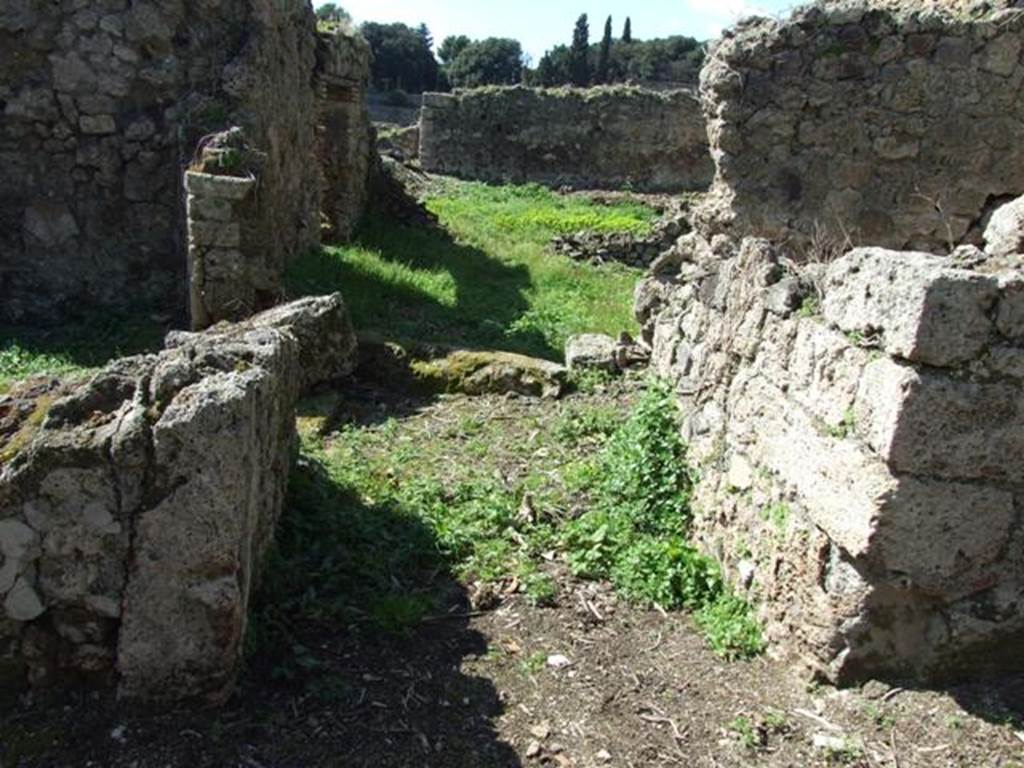 I.2.20 Pompeii. March 2009. Entrance. Looking west along short entrance corridor towards small atrium. According to Fiorelli, there was a painted graffito on the pilaster that divided the two entrances of I.2.20 and I.2.21. This would have been the remains of the pilaster on the left of the picture. It said:
CEIVM  II . VIR . OVF
POLLIVS CLIENS ROG  
See Pappalardo, U., 2001. La Descrizione di Pompei per Giuseppe Fiorelli (1875). Napoli: Massa Editore. (p.36)
According to Epigraphik-Datenbank Clauss/Slaby (See www.manfredclauss.de) this read as -
] Ceium IIvir(um) o(ro) v(os) f(aciatis) 
[3]ini v[3] cliens rog(at)           [CIL IV 3366]

