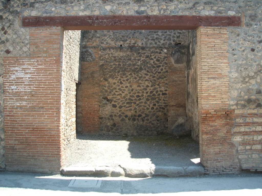 I.4.26 Pompeii. May 2005. Entrance, looking south. In the south-west corner of the workshop, upon excavation there were the remains of a hearth or basin. The doorway on the left leads to the large drying? room.   Fiorelli said that near to the doorway, one could read:
L . POPIDIVM . SECVNDVM
     AED .DIONYSIVS . L . ROGAT
M . CASELLIVM
See Pappalardo, U., 2001. La Descrizione di Pompei per Giuseppe Fiorelli (1875). Napoli: Massa Editore. (p.43)

According to Della Corte, the artisan Dionysius, established here, was not only tenant, but freedman of the proprietor. This he thought, as a result of these programmes written all to the left of the entrance:
L.  Popidium  L.  f.  Aed,  o. v. f.  
Dionysius  fullo  rog(at)  liber(tus)  [CIL IV 2966]
L.  Popidius  Secundum  
aed., Dionysius  l(ibertus)  rog(at)  [CIL IV 1041]
L.  Popidium  Secundum  
aedilem,  Pop(idi)us    
(Donysius)  rogat   [CIL IV 1045]
L. Popidium  aed.  Dionysius  rog(at).  Infans,  dormis  et  cupis ?  [CIL IV 2974]
See Della Corte, M., 1965.  Case ed Abitanti di Pompei. Napoli: Fausto Fiorentino. (p.256)


