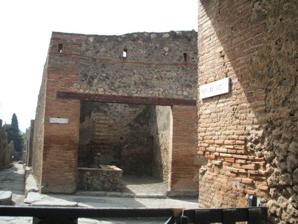 I.4.27 Pompeii. May 2005. 
Looking south from Vicolo di Tesmo, across Via dell’Abbondanza, towards entrance doorway on west side of Vicolo del Citarista. 

