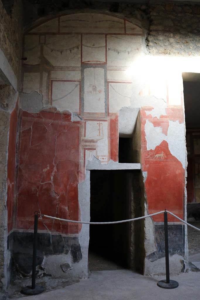 I.6.7 Pompeii. December 2018. 
Doorway to room in north-east corner of atrium, with a splayed window above.
On either side of the doorway are small paintings.
On the north side – an antelope, on the south side – a chariot with the attributes of Dionysus being pulled by panthers.
Photo courtesy of Aude Durand.
