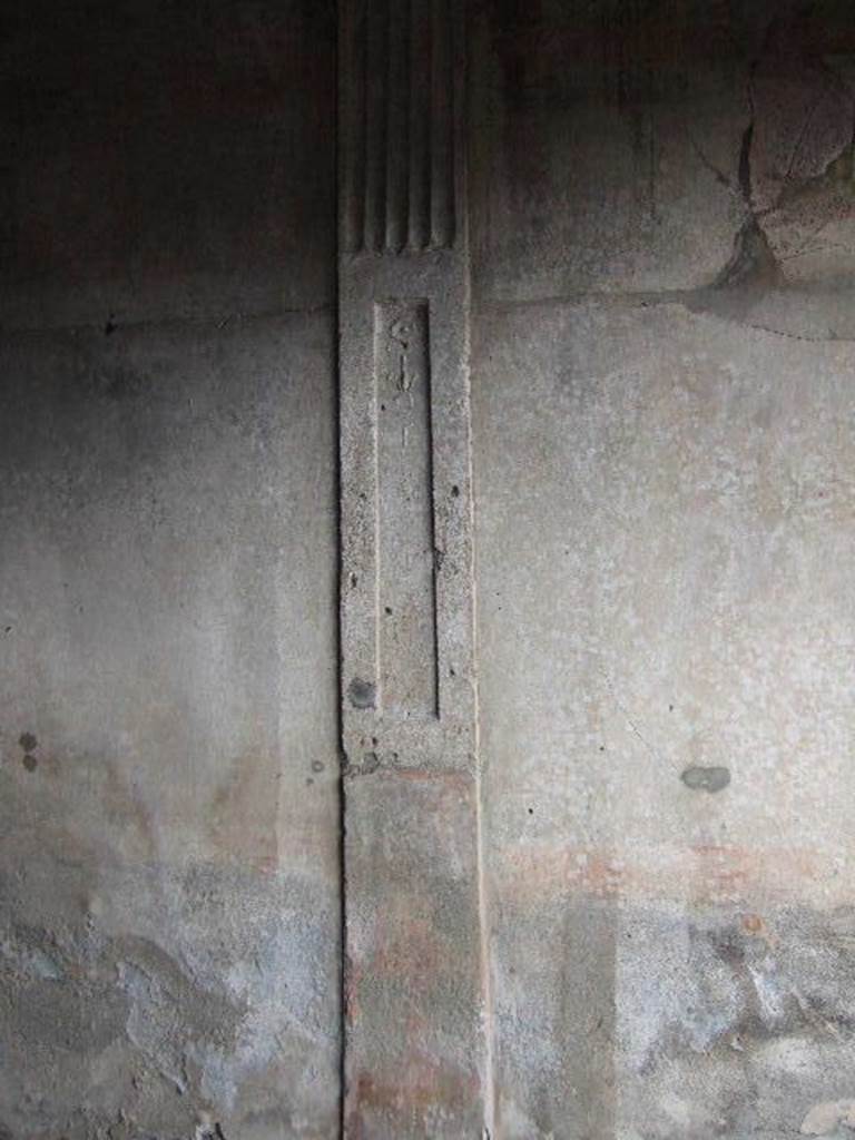 I.6.7 Pompeii. December 2005. East wall of triclinium. On the east wall is a stucco partition in relief, dividing the antechamber and the triclinium. The lower third was painted in red and the part above with a recess which was adorned with floral candelabra with plates.
