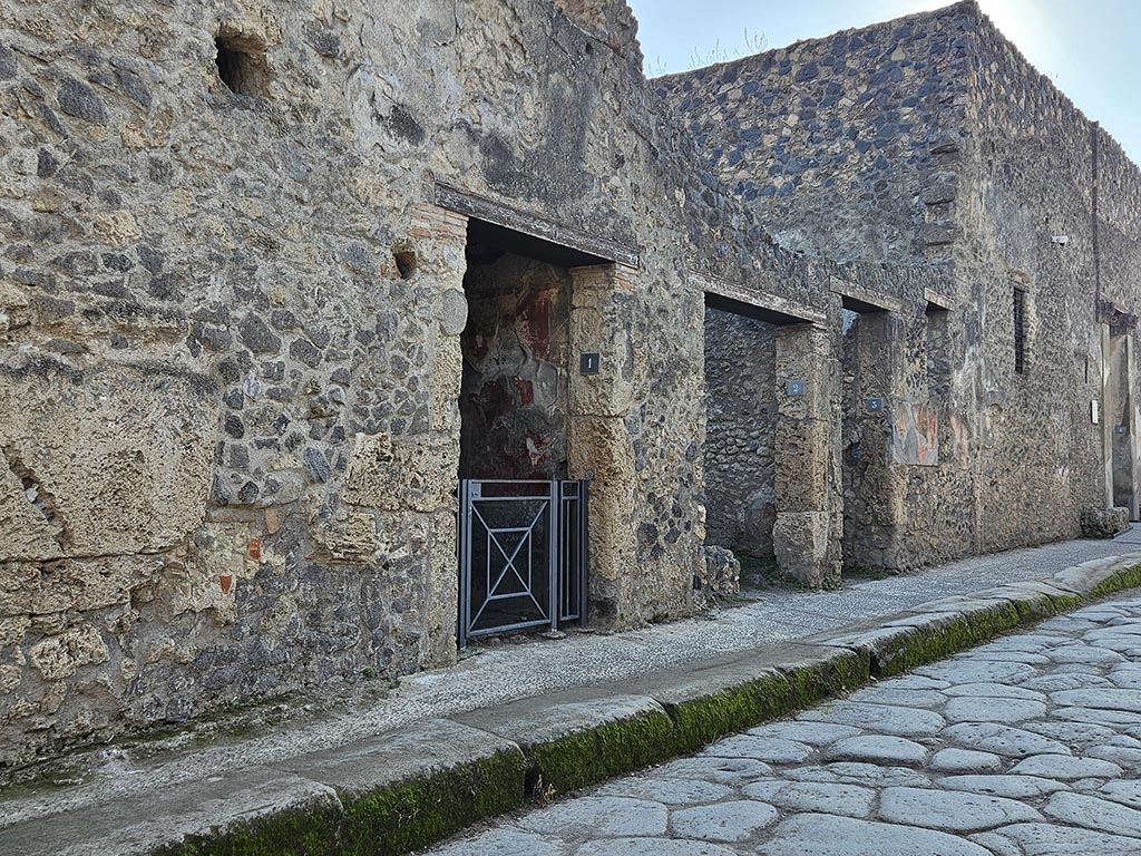 I.10.2 Pompeii. November 2024. Looking west towards doorways on south side of Vicolo del Menandro. Photo courtesy of Annette Haug.