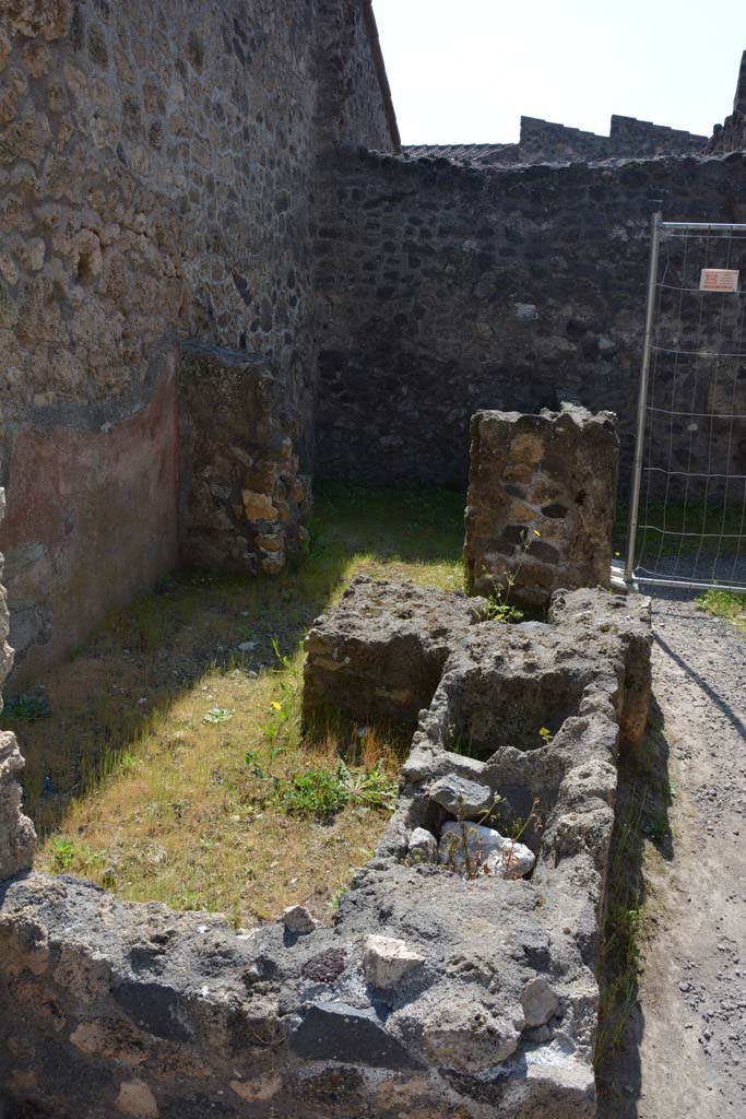 I.10.2 Pompeii. April 2017. 
Looking south across remains of podium, originally with two dolia and a hearth. 
In the south-east corner is a doorway to a rear-room. Photo courtesy Adrian Hielscher.
