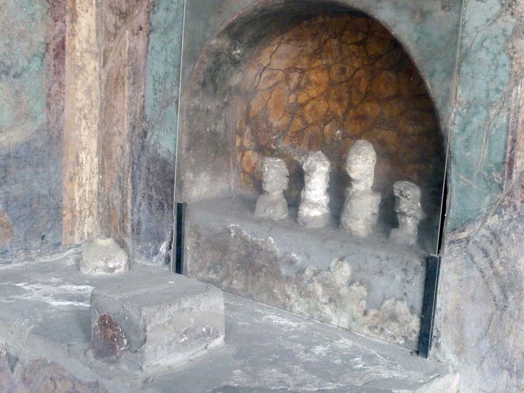 I.10.4 Pompeii. May 2010. 
Alcove 25, lararium or domestic shrine. The busts are plaster cast taken from the cavities left by the original wooden busts. 
