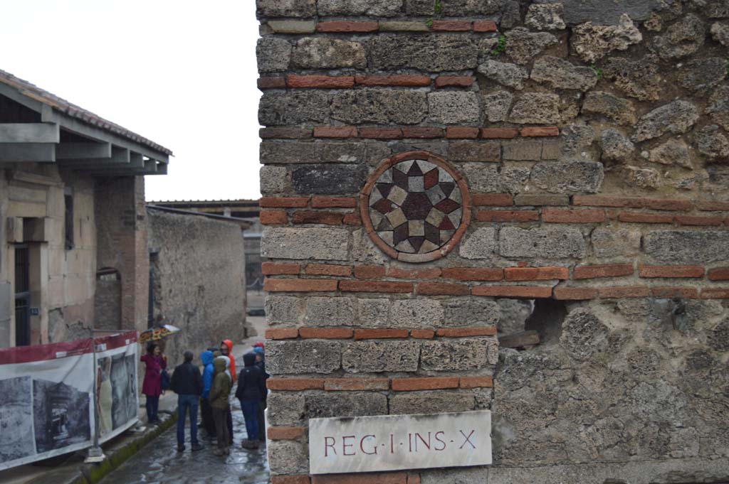 I.10.9 Pompeii. March 2018. 
Looking towards coloured terracotta plaque above doorway of I.10.9, and east along Vicolo del Menandro, on left.
Foto Taylor Lauritsen, ERC Grant 681269 DÉCOR.
