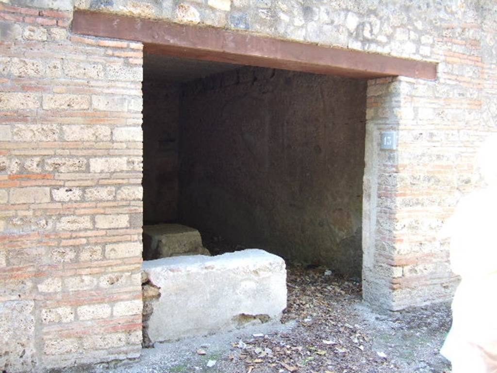 I.10.13 Pompeii. September 2005. Entrance doorway.
According to NdS, -
This wide doorway, with a wooden threshold and brick door-jambs, led into a rectangular room (6.10m x 3.50m) with walls covered by a high cocciopesto zoccolo, and upper walls plastered, the flooring was cocciopesto, and the ceiling was flat. 
In the west wall, other than a bricked-up doorway communicating with one of the rustic rooms of the Casa del Menandro, the first brick steps of a wooden stairs leading up to the mezzanine was found in the south-west corner. 
The threshold was occupied with two thirds of the short side of the brick counter covered in cocciopesto and painted red, having the hearth at the west end of the long side and two small clay dolia embedded into it.
For the finds, found on this counter, see NdS, 1934, p.340.
For details of “finds” from this house, 
See Allison, P.M. (2006). The Insula of the Menander at Pompeii: Vol. III The finds, Clarendon Press, Oxford, (p.248 & p.367).


