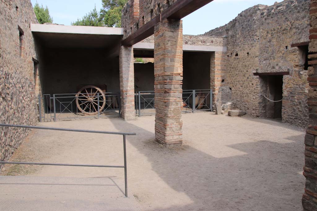 I.10.14, Pompeii. September 2021. 
Looking towards east side of stable, with two-wheeled cart and blocked doorway. Photo courtesy of Klaus Heese.
