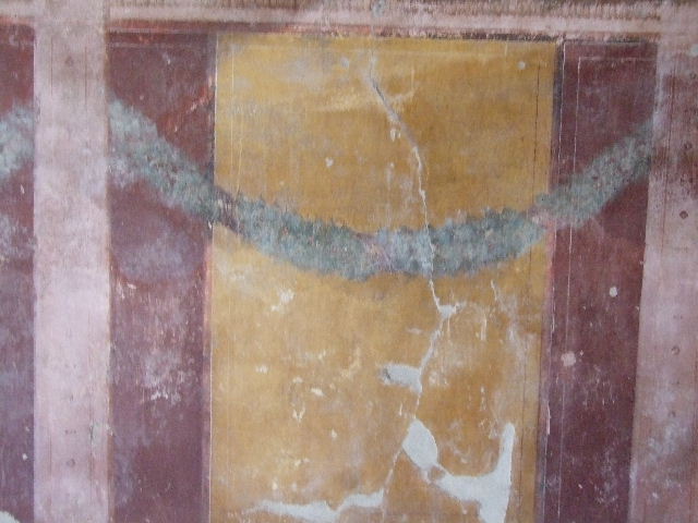 I.11.14 Pompeii. December 2006. Detail of wall painting with garland from north wall of oecus.  