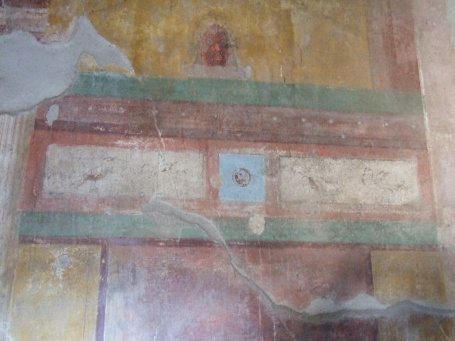 I.11.14 Pompeii. December 2006. Detail of wall painting from east wall of oecus, with medallion, birds and mask.