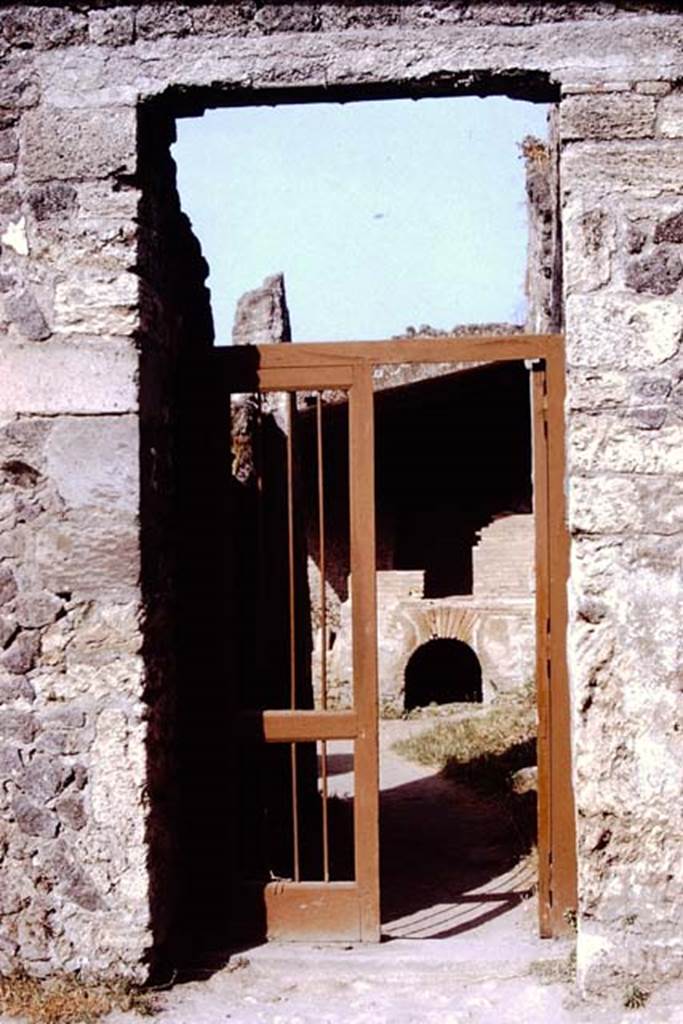 I.20.3 Pompeii. 1972. Entrance doorway. Photo by Stanley A. Jashemski. 
Source: The Wilhelmina and Stanley A. Jashemski archive in the University of Maryland Library, Special Collections (See collection page) and made available under the Creative Commons Attribution-Non Commercial License v.4. See Licence and use details. J72f0110
According to Wilhelmina, writing about a hole discovered in the garden of I.15.3, 
“When the heavy growth had been cleaned from the hole, it was noticed that the hole had a yellow colour, which it was thought may have been potter’s clay, but of a quality that would have required much work to refine it. It may have been the source of the clay used at the nearby lamp and dice box factory. Prof. Cerulli Irelli  had taken them to see this small factory which she had been studying. The moulds in which the lamps were made, the finished lamps, and the kiln in which they would have been fired were all seen.  The lamps had all types of decoration such as deities, birds and plants. Wilhelmina especially liked the one of a small cupid trudging along, carrying two huge baskets of produce, perhaps grapes, hanging from a pole resting on his shoulders.”
See Jashemski, W.F., 2014. Discovering the Gardens of Pompeii: Memoirs of a Garden Archaeologist, (p.189-192????)

