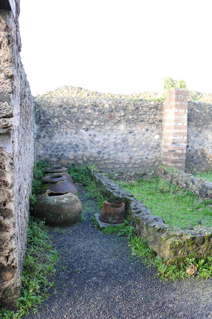 I.21.2 Pompeii. December 2018. 
Looking towards west wall, dolia and puteal. Photo courtesy of Aude Durand.
