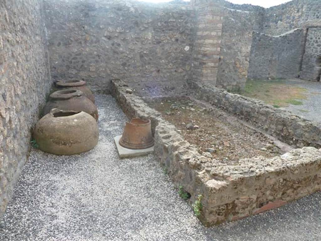 I.21.2 Pompeii. September 2015. Looking towards west wall and dolia, puteal, and remains of plaster on basin/vat.