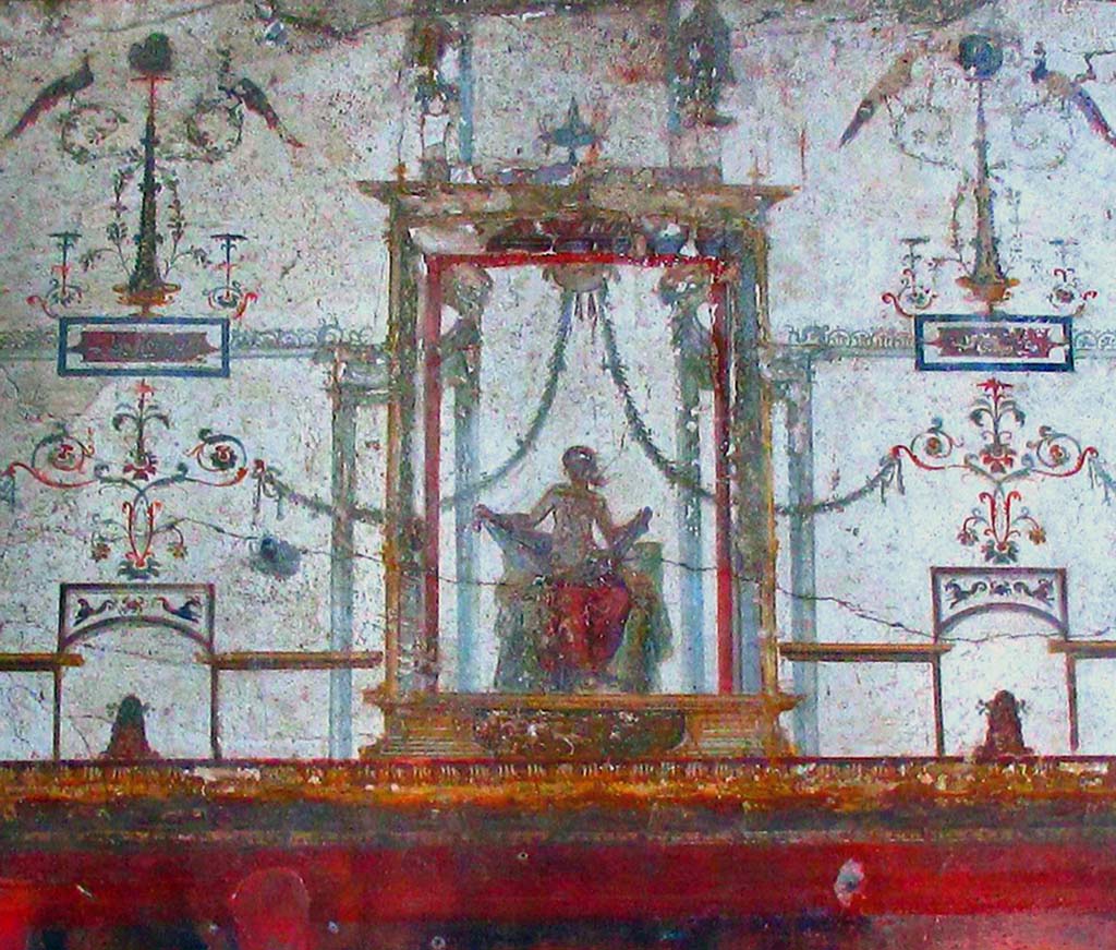 II.2.2 Pompeii. April 2016. 
Room “f”, detail of upper centre of west wall with fresco in Fourth style of seated figure. Photo courtesy of Davide Peluso.

