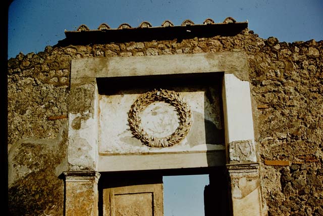 II.2.4 Pompeii. May 2016. Detail of emblem decoration above entrance doorway.
Photo courtesy of Buzz Ferebee.
