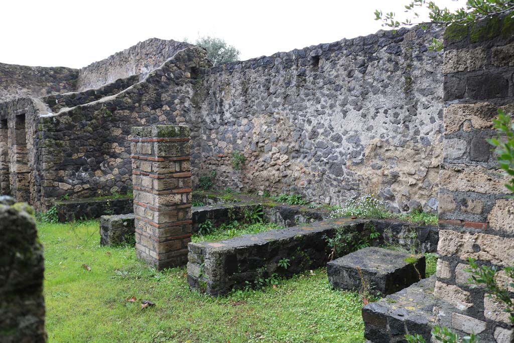 II.8.5 Pompeii. December 2018. 
Three-sided stone benches and tables built against the north wall, viewed from the east end. Photo courtesy of Aude Durand.

