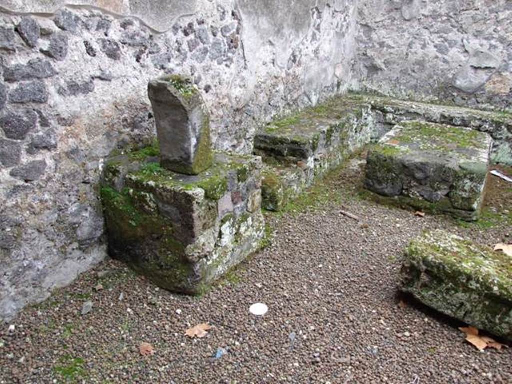 II.8.5 Officina di Sabbatino.  December 2007.  Three sided stone bench and table in south west corner of atrium area.