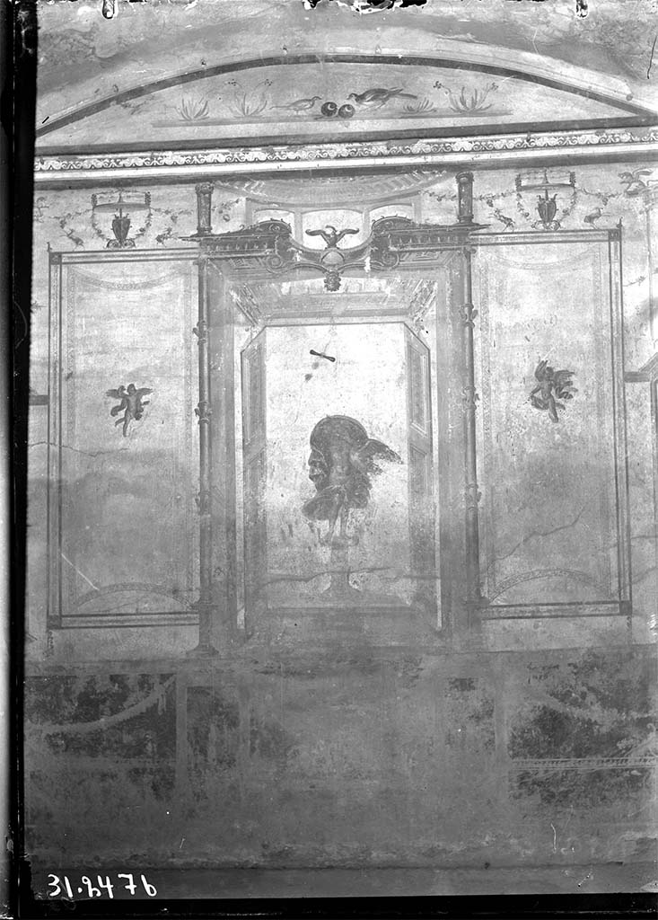 V.2.1 Pompeii. 1931? Room 8, looking towards west wall.
DAIR 31.2476 Photo © Deutsches Archäologisches Institut, Abteilung Rom, Arkiv. 
The zoccolo was red subdivided with panels with carpet borders and garlands.
In the centre was Leda and the Swan in an aedicula with doors at each side and with an eagle on a globe above.
In the side panels were carpet borders, curved on the short sides and with cupids in the centre of each panel and above were goats and garlands.
In the lunette above were birds with fruit and with flowers at the sides.
See Carratelli, G. P., 1990-2003. Pompei: Pitture e Mosaici: Vol. III. Roma: Istituto della enciclopedia italiana, p. 776-7.
