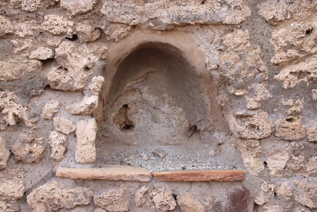 V.2.9 Pompeii. October 2022. Small niche lararium on west wall of shop-room. Photo courtesy of Klaus Heese.