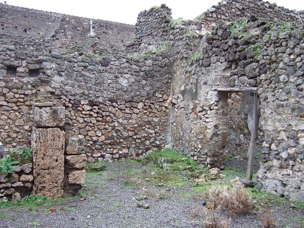 V.2.f, Pompeii. December 2005. Looking south-east across atrium. On the left would have been a cubiculum.
In the centre can be seen a room with remains of three masonry steps to an upper room above the cubiculum, and doorway to a small courtyard. 
According to NdS, on the black dado of the room with the stairs was a graffito – MID/
See Notizie degli Scavi di Antichità, 1896, (p.436).
See Mau in Bullettino dell’Instituto di Corrispondenza Archeologica (DAIR), VIII, 1893, (p.7-9)
According to Jashemski, a terracotta dolium and several amphorae were found in the courtyard.
See Jashemski, W. F., 1993. The Gardens of Pompeii, Volume II: Appendices. New York: Caratzas, (p.112)
