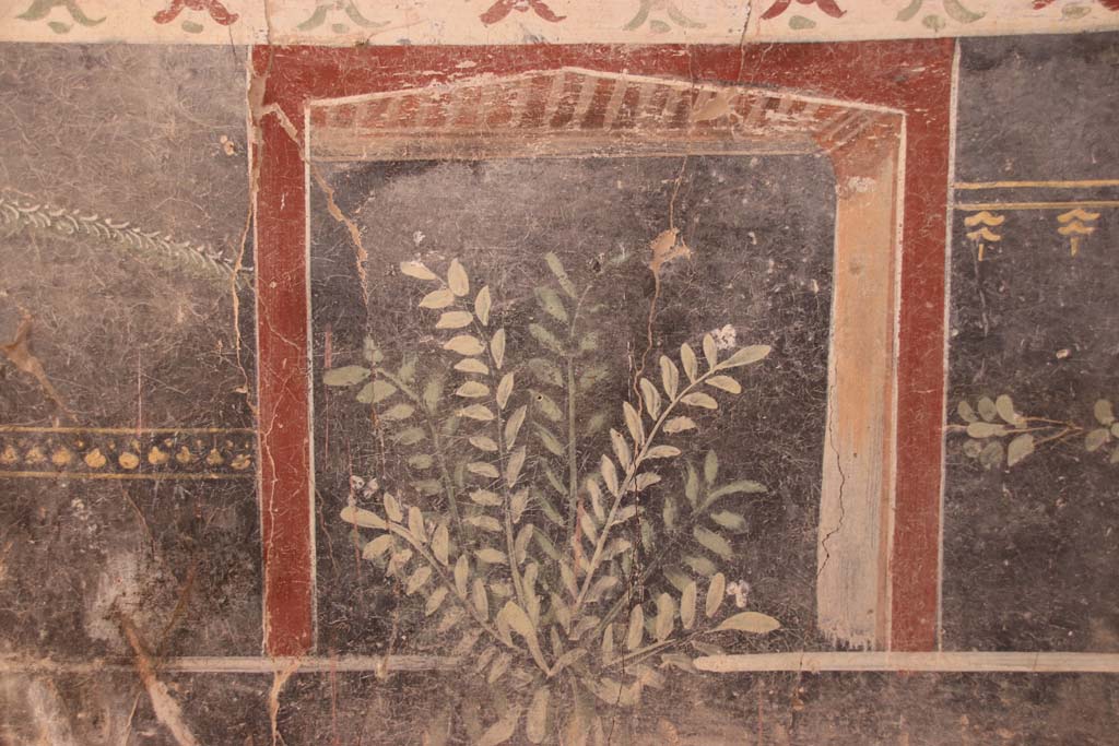 V.3 Pompeii. Casa del Giardino. September 2021. 
Room 1, south wall, painted plant decoration on zoccolo at west end. Photo courtesy of Klaus Heese.

