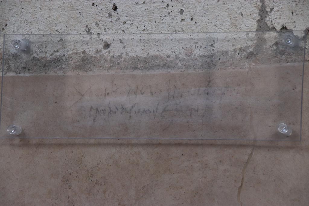 V.3 Pompeii. Casa del Giardino. October 2022. Room 5, graffiti on east wall of atrium. Photo courtesy of Klaus Heese.