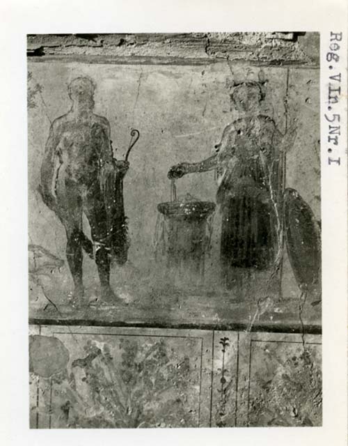 V.4.3 Pompeii. Undated watercolour by Luigi Bazzani. Lararium painting from west wall of atrium.
Kuivalainen describes –
“On the left side of the aedicula is a youth standing with his weight on his right foot. He wears a long cloak and pours wine from a cantharus, turned upside-down in his right hand; in his left hand he holds a thyrsus. A sitting panther raises its right front leg and drinks the wine. The figure is surrounded by growing vines, which are shaped into an arch.”
Kuivalainen comments – 
“An almost naked young Bacchus offering wine to a panther, depicted as a counter-part to Jupiter as the main figures by the aedicula.”
See Kuivalainen, I., 2021. The Portrayal of Pompeian Bacchus. Commentationes Humanarum Litterarum 140. Helsinki: Finnish Society of Sciences and Letters, (p.115-16, C16).
