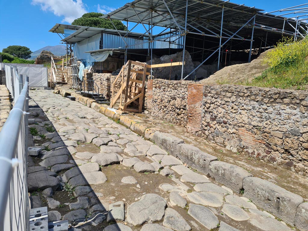 V.6.11 Pompeii. May 2024. 
Looking north towards east side of Via del Vesuvio, with entrance doorway with wooden steps, in centre. Photo courtesy of Klaus Heese.
