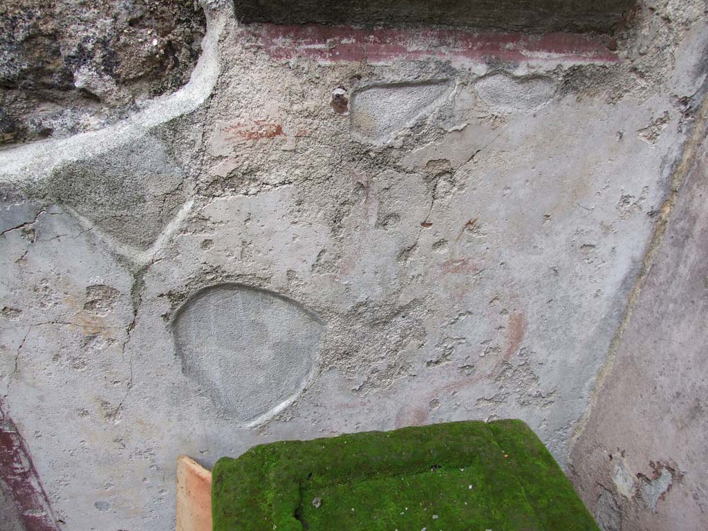 VI.7.23 Pompeii. December 2006. Kitchen, niche above household altar on north wall of kitchen. According to Boyce, the inside walls were coated with white stucco, the corner outlined with broad red stripes.
Beneath it the floor projects from the surface of the wall. On the back wall of the niche was painted the figure of the Genius, holding a patera with his right hand above a flaming altar. The wall around the niche was covered with a panel of the same white stucco, bordered in red.
On each side of the niche was painted a Lar in yellow tunic and red pallium. See Boyce G. K., 1937. Corpus of the Lararia of Pompeii. Rome: MAAR 14. (p.48, no.167, and Pl.11,1 ) 
